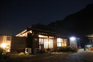 een huis 's nachts met de lichten aan bij Kominka Sauna & BBQ TK-tei in Ichihara