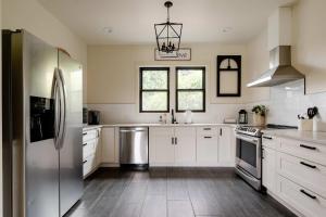 ポートランドにあるCharming SE Home - Farmhouse Style - Remodeledの白いキャビネットとステンレス製の冷蔵庫を備えたキッチン