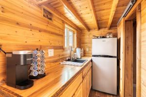 a kitchen with a refrigerator in a wooden cabin at Stay Portland - Tiny Log Cabin - Walk to Local Shops & Eateries in Portland