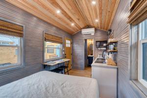 a tiny house with a bed and a kitchen at Stay Portland - Tiny Aztec - Walk to Local Shops & Restaurants in Portland