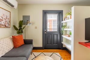 a living room with a gray couch and a black door at Stay Portland - Quirky Micro Apt - Foodies, Artists, Coffee Lovers in Portland