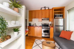 a kitchen with wooden cabinets and a couch in a room at Stay Portland - Quirky Micro Apt - Foodies, Artists, Coffee Lovers in Portland