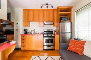 a kitchen with wooden cabinets and stainless steel appliances at Stay Portland - Quirky Micro Apt - Foodies, Artists, Coffee Lovers in Portland