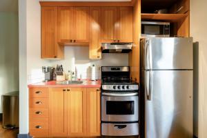a kitchen with wooden cabinets and a stainless steel refrigerator at Stay Portland - Color Splash Apartment in the Heart of Portland in Portland