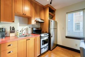 a kitchen with wooden cabinets and a stainless steel refrigerator at Stay Portland - Color Splash Apartment in the Heart of Portland in Portland