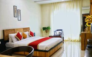 een slaapkamer met een groot bed en een raam bij Collection O Bargi Hills Near IT park in Jabalpur