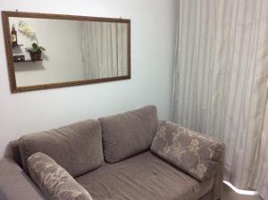 a couch in a living room with a mirror at Apartamento Aconchego Do Recreio in Rio de Janeiro