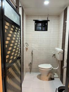 a bathroom with a toilet and a window at WKND Casa in Panchgani