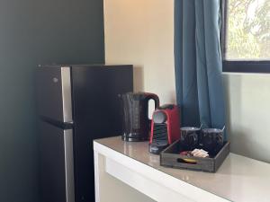 a kitchen counter with a black refrigerator and a tray at Woodstock Palmresort Curacao - Iguana Kamer in Santa Catharina