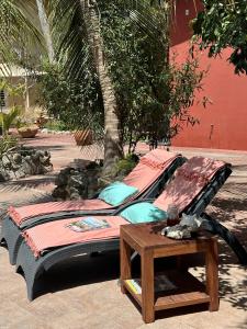 a bed and a table next to a tree at Woodstock Palmresort Curacao - Iguana Kamer in Santa Catharina