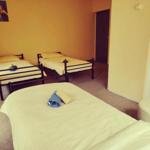 a room with three beds and a hat on a bed at Clara Family Room in Cluj-Napoca