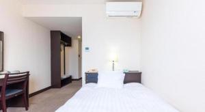 Postel nebo postele na pokoji v ubytování Tabist Hotel New Osamura Sabae