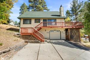 a house with a deck and a garage at Bear Canyon: Large Cabin, Beautiful Views & HotTub in Big Bear Lake