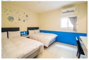 a hotel room with two beds and a window at Ryhan Hotel in Zhongli
