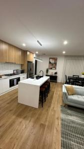 a kitchen with a white island in a living room at Urban Pause Retreat - Wollert in Wollert