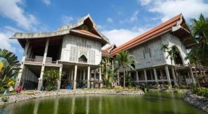 a large building with a pond in front of it at Nipah River view in Kampong Losong