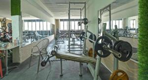 a gym with tread machines and chairs in a room at Super OYO Capital O 90659 Raintown Timbers Hotel in Taiping