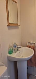 Un baño con un lavabo blanco y un espejo. en Heavenly Huts GC056, en Saint Osyth 22 fotos más