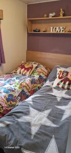 una cama con un edredón que dice te amo en Heavenly Huts GC056, en Saint Osyth