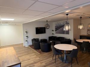une salle d'attente avec des tables et des chaises et une télévision dans l'établissement Mathias Kök & Rum, à Vårgårda