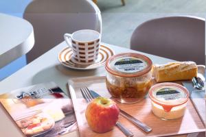 a table with an apple and jam and a cup of coffee at Hotel Daumesnil-Vincennes in Vincennes +72 photos