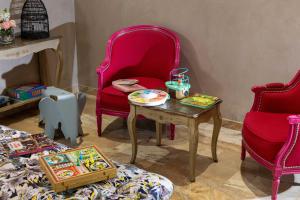 a living room with two chairs and a table and a tableablish at Hotel Daumesnil-Vincennes in Vincennes