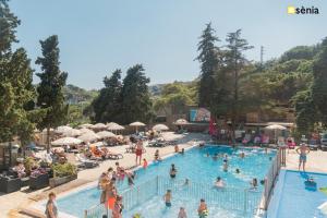 eine Gruppe von Personen in einem Pool in einem Resort in der Unterkunft Happy Camp mobile homes in Camping Sènia Cala Canyelles in Lloret de Mar