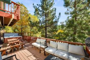 a deck with a couch and a table and a bench at Bear Canyon: Large Cabin, Beautiful Views & HotTub in Big Bear Lake +21 photos