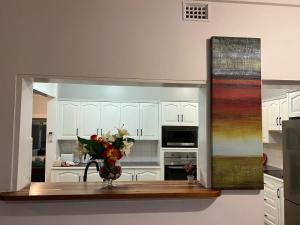 a kitchen with a vase of flowers on a counter at The Waratah Escape Nowra in Nowra +10 photos