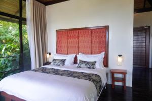 a bedroom with a large white bed and a window at Hidden Gardens Resort, Davao in Davao City