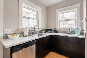 une cuisine avec un évier et une fenêtre dans l'établissement Stay Portland - PDX Art Deco Lounge - Local Eateries, Bars & Shops, à Portland