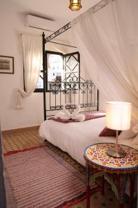 a bedroom with a bed and a table with a lamp at Dar Rass El Maa in Chefchaouene