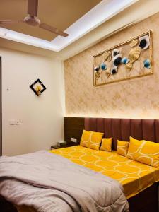 1 dormitorio con 1 cama con almohadas amarillas y azules en Ghar - near expo mart -cozy stay away from home, en Greater Noida
