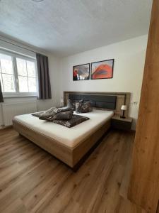 a bedroom with a large bed with wooden floors at Ferienwohnung Höllrigl in Sankt Leonhard im Pitztal