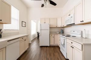 a kitchen with white cabinets and a white refrigerator at Stay Portland - Renovated 3BR Tilikum View in heart of SE Division in Portland