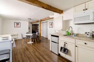 a kitchen with white cabinets and a table with chairs at Cozy Portland Home Steps from Food - Sleeps 4 in Marquam Hill