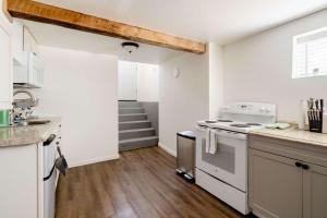 a white kitchen with a stove and a sink at Cozy Portland Home Steps from Food - Sleeps 4 in Marquam Hill +12 photos