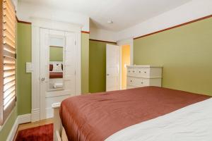 - une chambre avec des murs verts et blancs et un lit dans l'établissement Stay Portland - Sun-filled Home in Buckman Neighborhood with 2BRs, à Portland