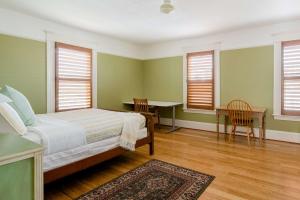 une chambre avec un lit, un bureau et des fenêtres dans l'établissement Stay Portland - Sun-filled Home in Buckman Neighborhood with 2BRs, à Portland