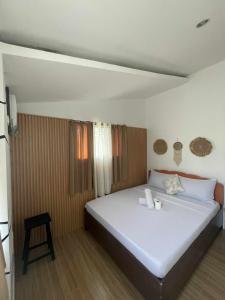 a bedroom with a large white bed in a room at Island Hop Inn in El Nido