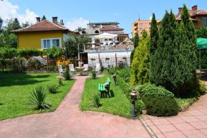 a garden with a bench and a fire hydrant at Hotel Tintyava 2 in Varshets