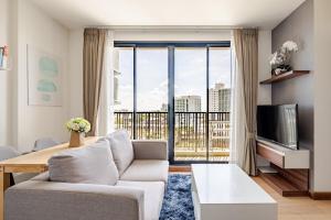 a living room with a couch and a large window at Astra condo - Deluxe room in Chiang Mai