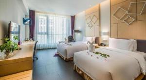 a hotel room with two beds and a window at Four Points by Sheraton Haikou International Airport in Haikou +63 photos
