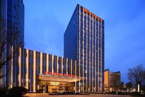 een groot gebouw met een bord aan de voorkant bij Wanda Realm Hotel Dongying in Dongying