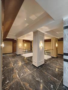 a large room with a marble floor and a ceiling at Hotel Srimanta sankardev in Majuli