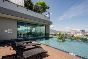 a swimming pool with two benches on a building at Astra condo - Deluxe room in Chiang Mai