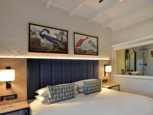 a bedroom with a large bed with three pictures on the wall at ANEW Resort Hazyview Kruger Park in Hazyview