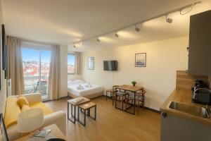 ein Wohnzimmer mit Sofa und Tisch in der Unterkunft Beau studio rénové, balcon, accès plage, piscine in Biarritz