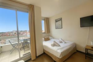 ein Hotelzimmer mit Bett und Balkon in der Unterkunft Beau studio rénové, balcon, accès plage, piscine in Biarritz