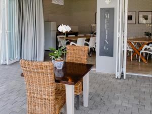 a table with wicker chairs and a table with a plant on it at Bateleur Guesthouse in Klerksdorp